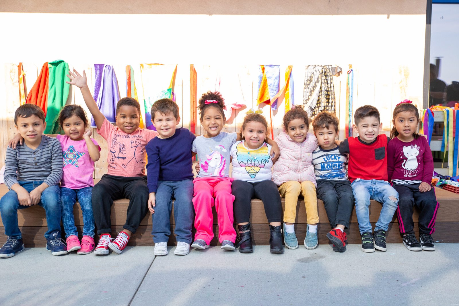 A group of children sitting on top of a bench.