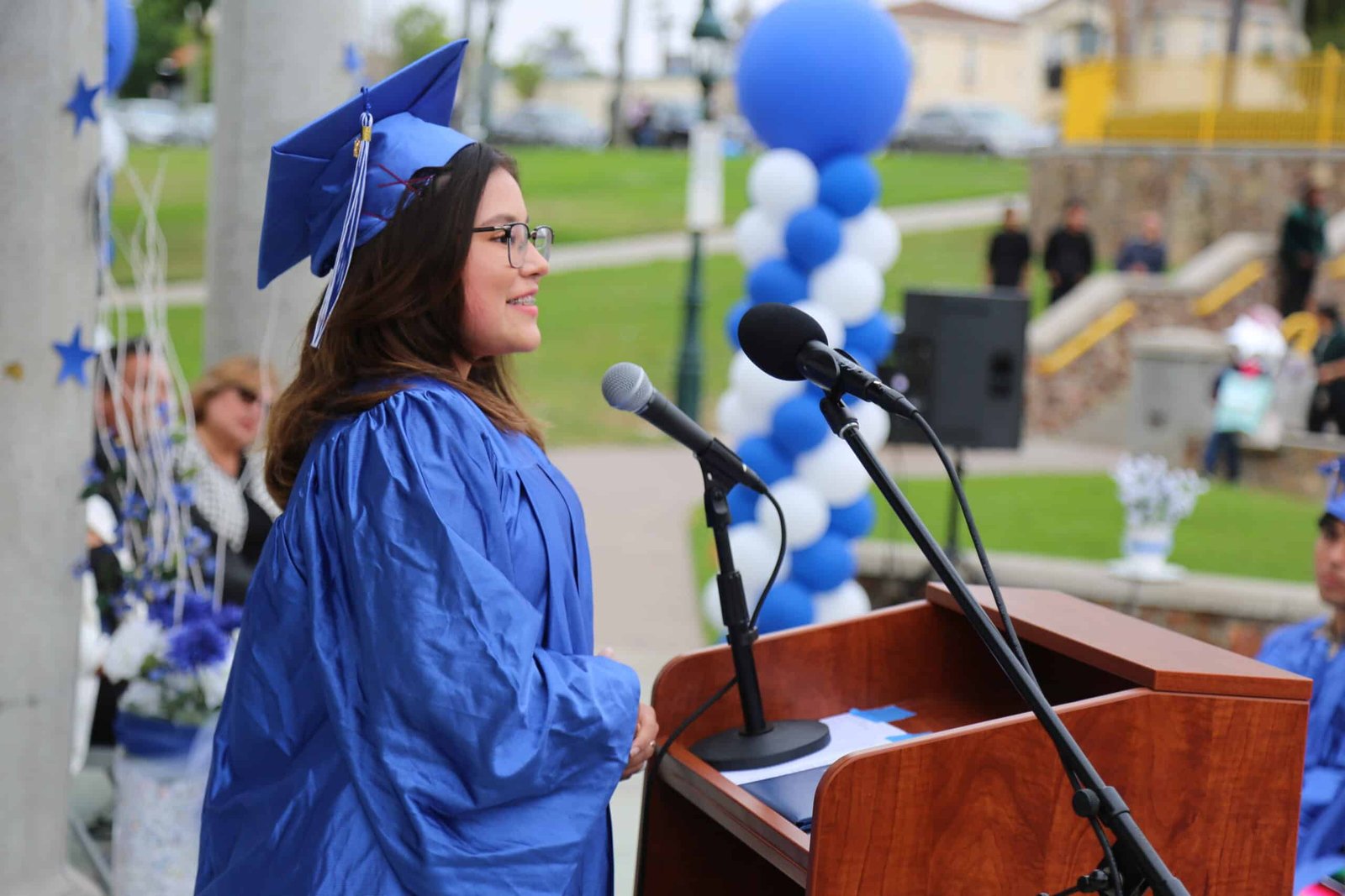 MCCS student A girl in blue cap and gown speaking at podium.