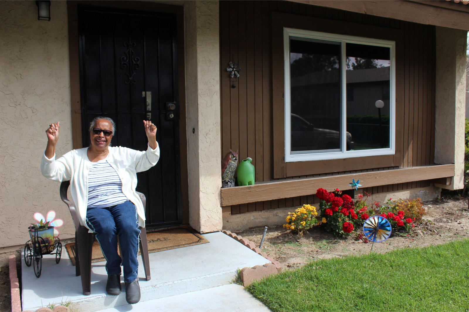 Charlena at home A woman sitting on the front porch of her house.