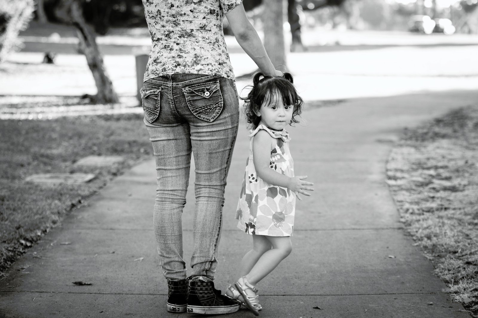 A woman and child walking down the sidewalk.
