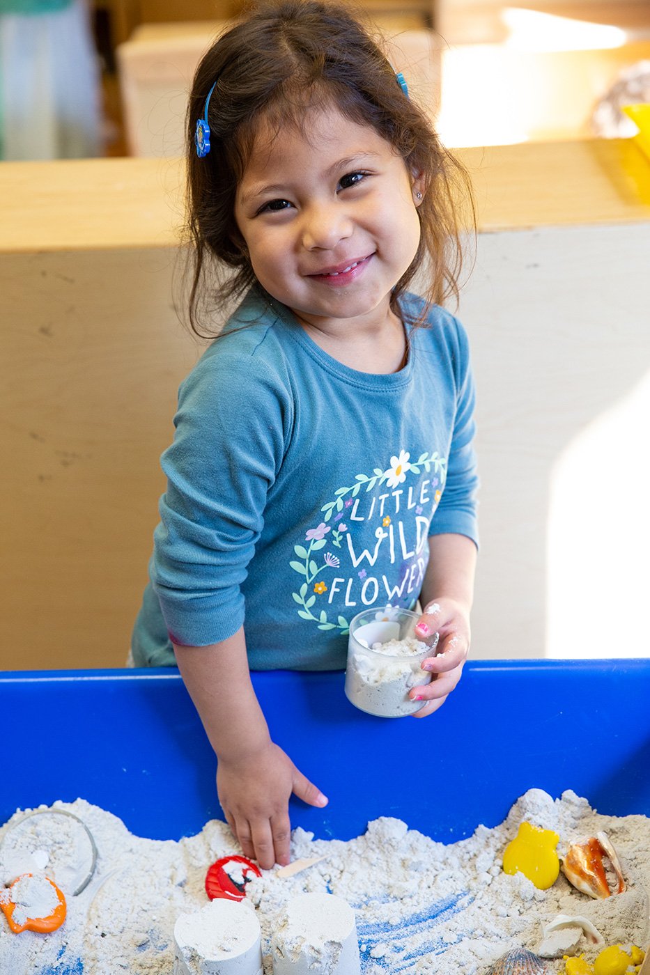A little girl is playing with some white stuff