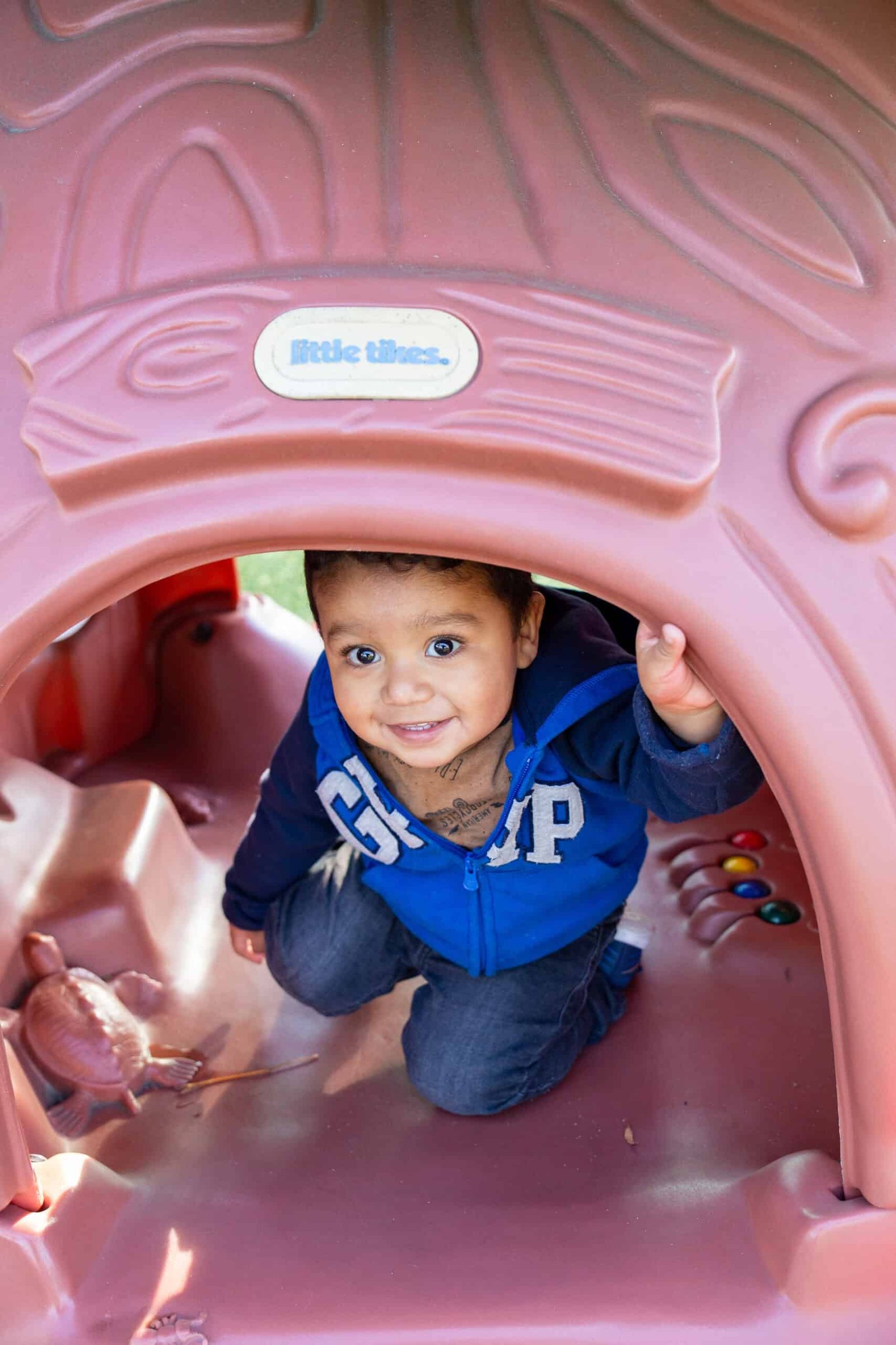 A young boy is playing in the tunnel.