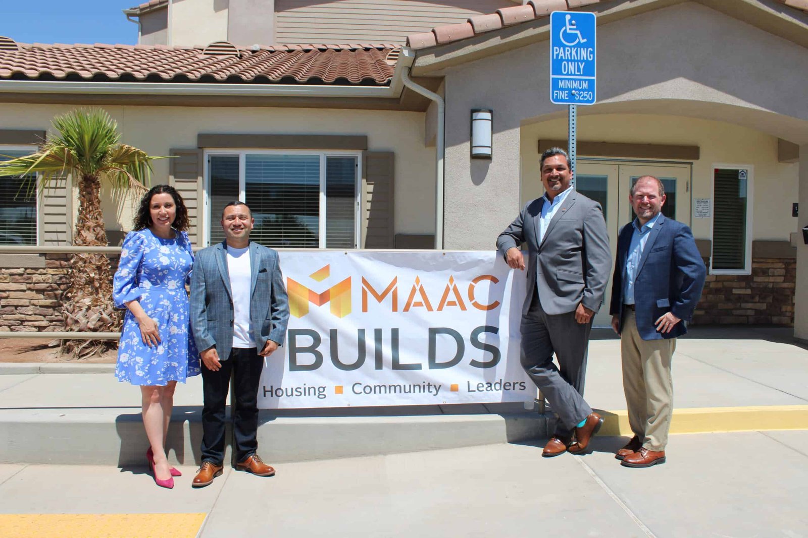MAAC builds team photo A group of people standing in front of a building.