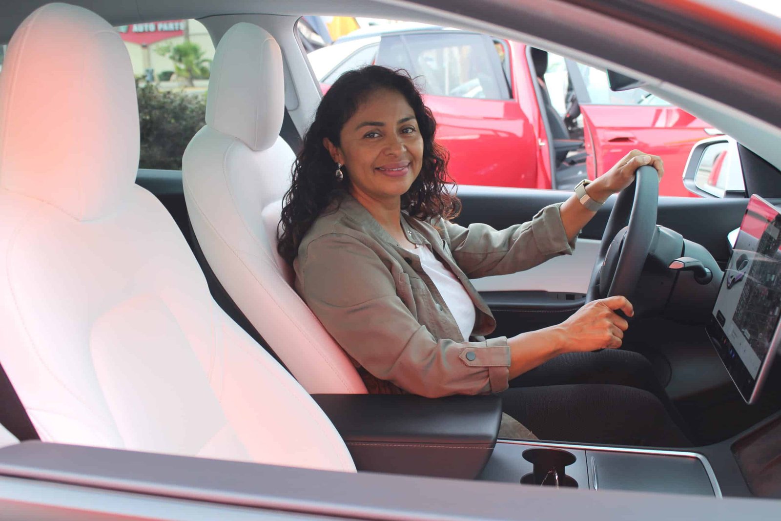 MAAC EV Program Tesla A woman sitting in the driver 's seat of her car.