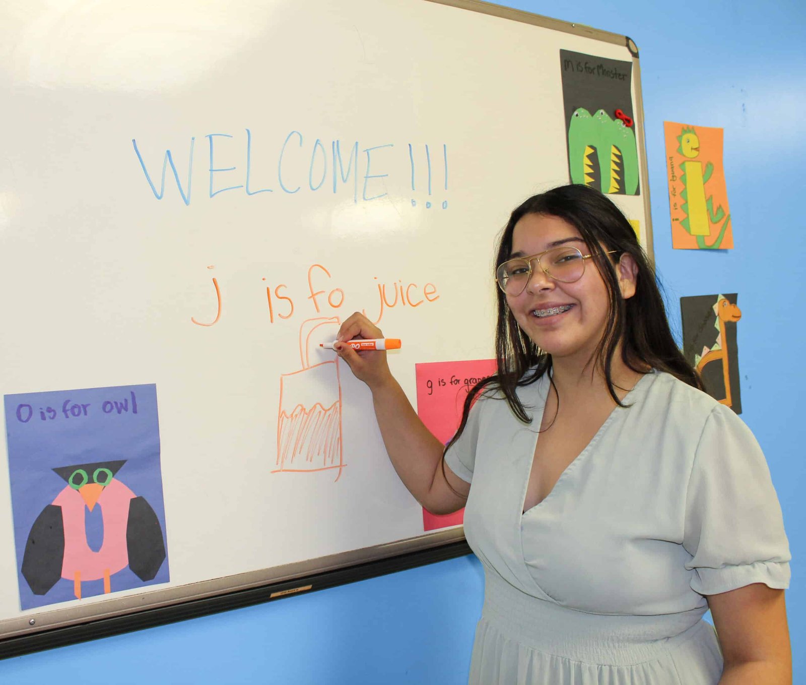 A woman is writing on the board in front of her.