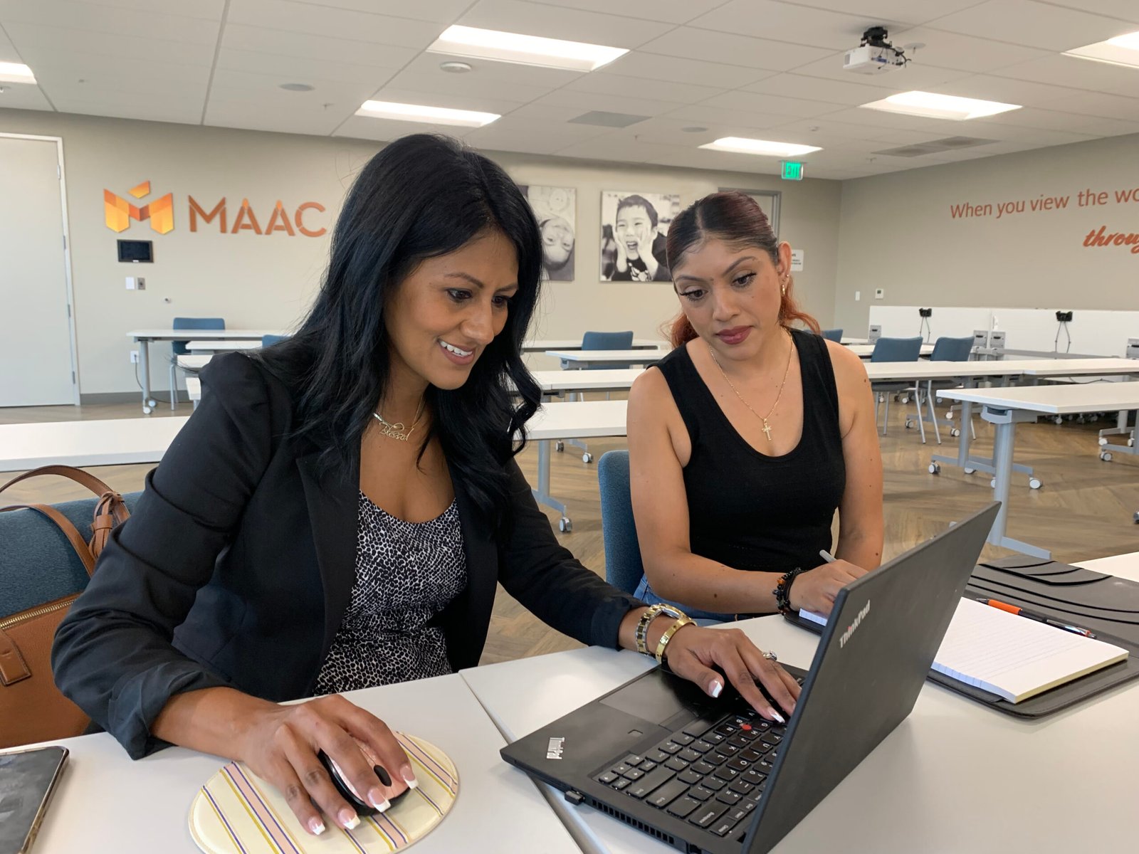 Women at MAAC Two women sitting at a table with laptops.