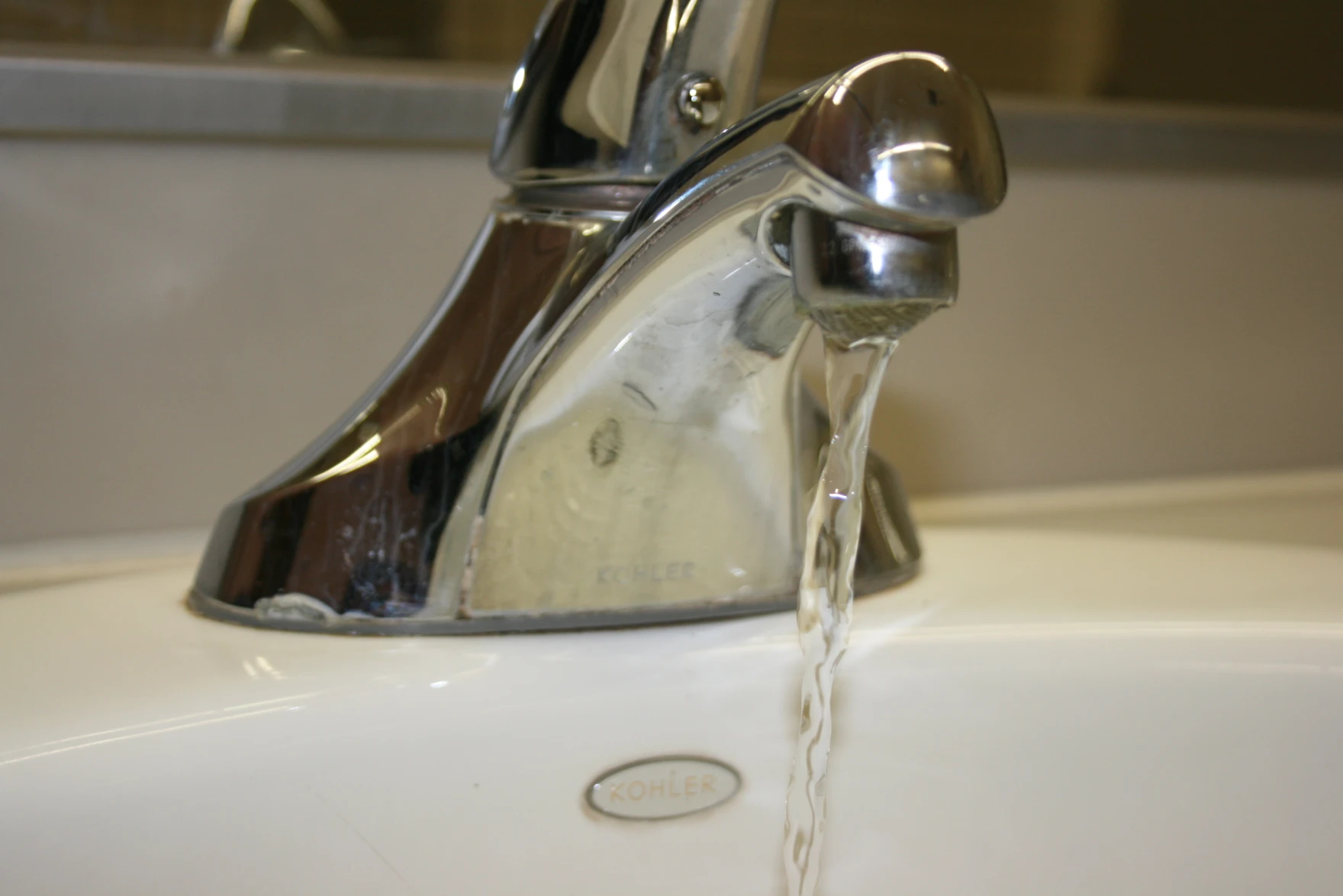 A faucet that is leaking water from the sink.