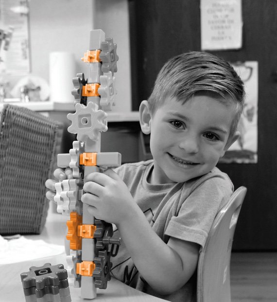 A boy holding onto some blocks in his hands
