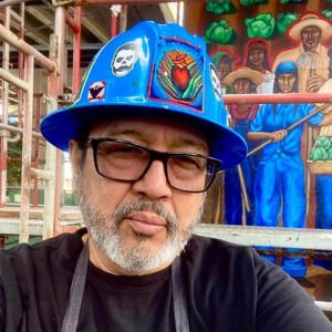 A man wearing glasses and a blue hat.